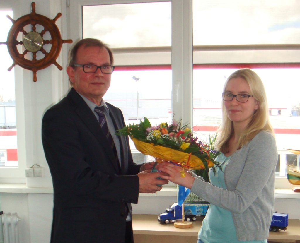 Abteilungsleiter Jürgen Finke überreicht in Namen des Hauses die Glückwünsche und den Blumenstrauß.